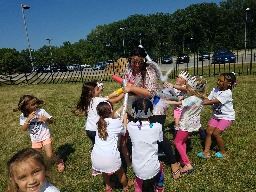 Kids surround counselor playing